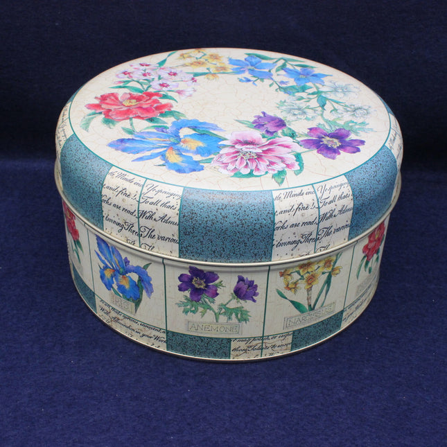 Round decorative tin with floral and script design on a dark blue background