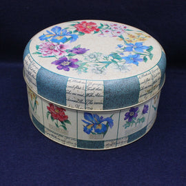 Round decorative box with floral patterns on a dark blue background