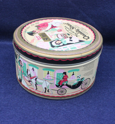 Decorative round tin with colorful illustrations on a blue background