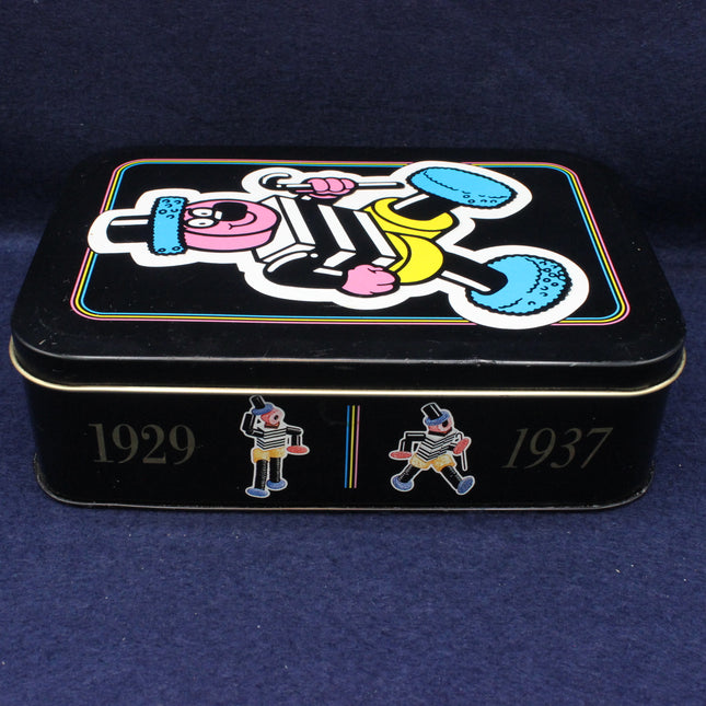 Decorative tin box with cartoon design and years 1929 and 1937 on a dark blue background