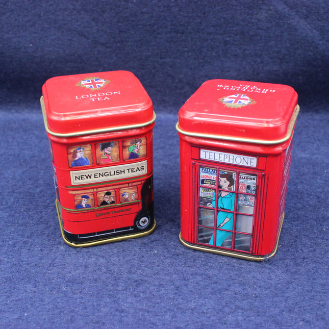 Two red tea tins with London-themed designs on a blue background