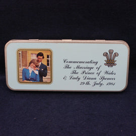 Memorabilia tin commemorating the marriage of Prince Charles and Lady Diana Spencer on a dark background