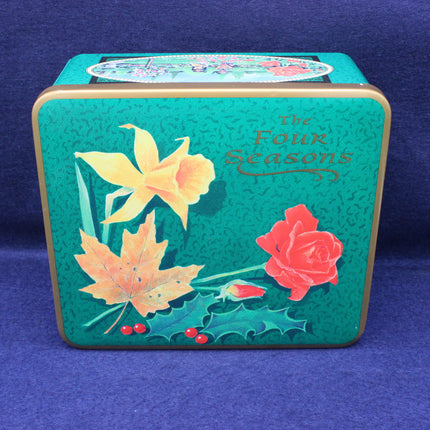 Decorative tin box with floral designs and 'The Four Seasons' text on a blue background