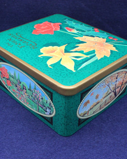Decorative tin box with floral designs on a blue background
