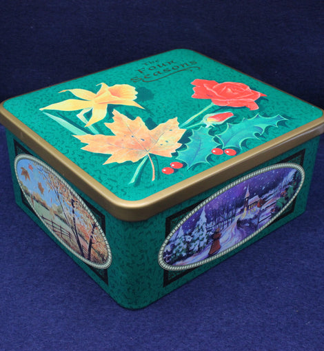 Decorative tin box with floral and landscape designs on a blue background
