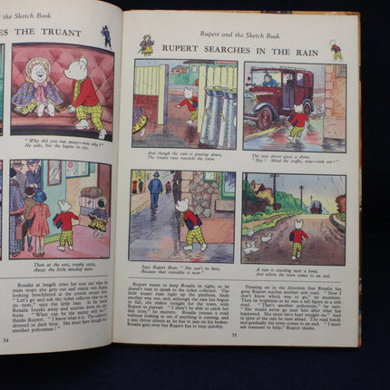 Open book showing comic strip of Rupert the Bear in various scenarios.