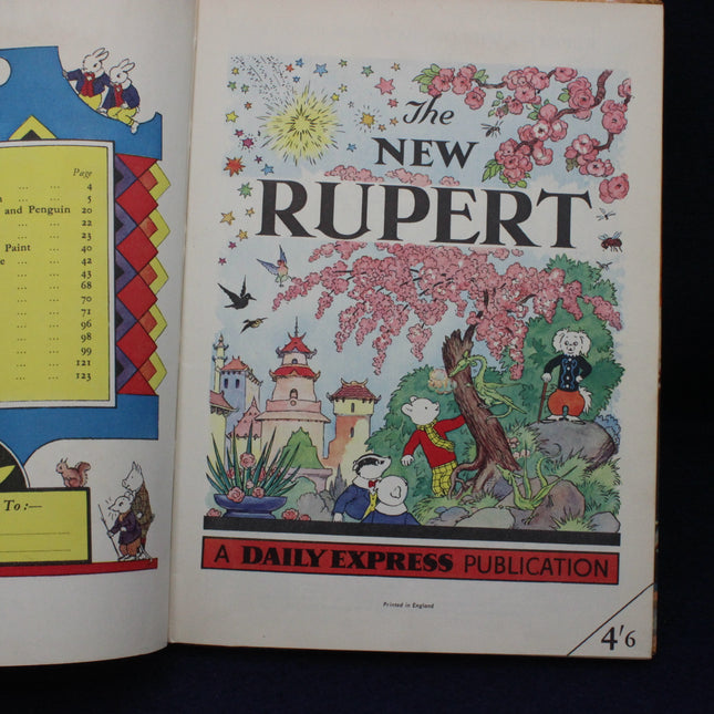 Illustrated cover of 'The New Rupert' featuring Rupert Bear and other characters with a castle and flowers.