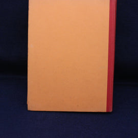 Close-up of a book with a red spine on a dark blue background