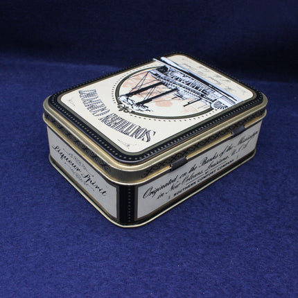 Decorative tin box with intricate design on a blue background