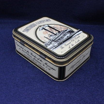 Vintage-style tin box with decorative lid on a blue background