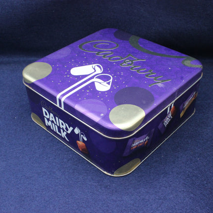 Purple chocolate tin with 'Cadbury' branding on a blue background