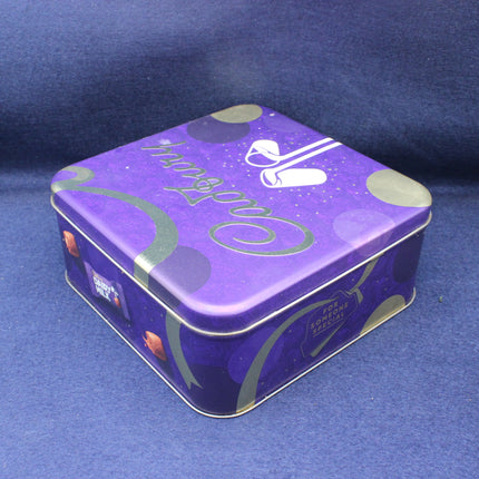 Purple tin box with decorative design on a blue background