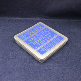 Box of Harrogate Toffee with blue label on a dark blue fabric background