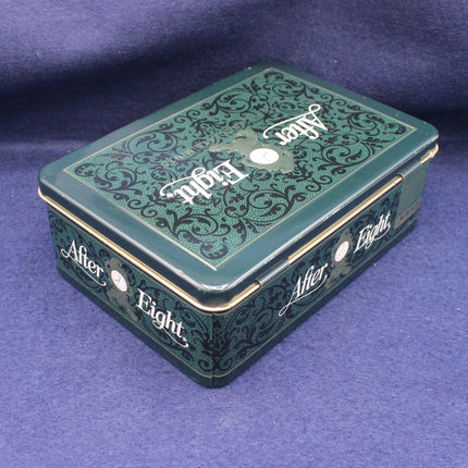 Decorative green tin box with 'After Eight' branding on a purple background
