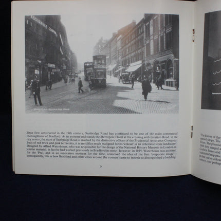 Open book with a black and white photograph of a city street scene on the left page.