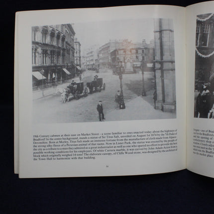 Open book with black and white photograph of a street scene and text on a dark background