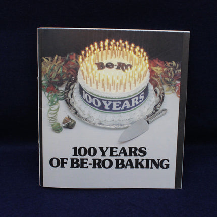 Book cover with a birthday cake and '100 Years of Be-Ro Baking' text on a dark background