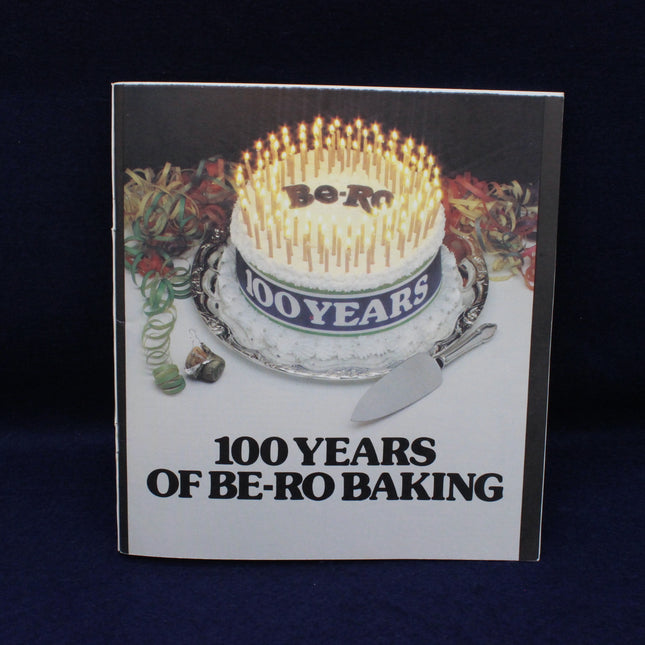 Book cover with a birthday cake and '100 Years of Be-Ro Baking' text on a dark background