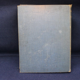 Vintage book with a textured blue cover on a dark background
