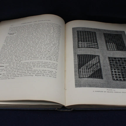 Open book with text and black and white illustrations on a dark background