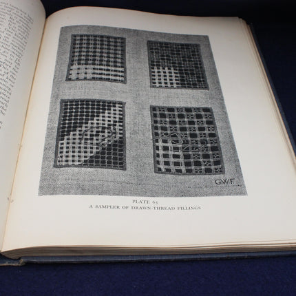 Open book with a black and white textile pattern illustration on a dark blue background