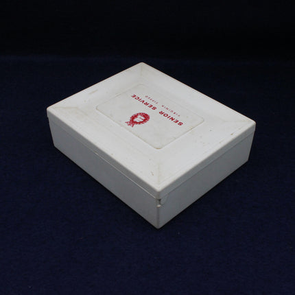 White jewelry box with a red logo on a black background