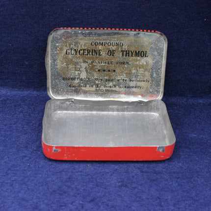 Vintage red and silver metal container with text on a blue background