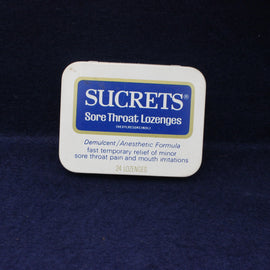 Sucrets sore throat lozenges container on a dark background