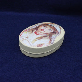 Round trinket box with a painted design of a woman's face on a blue background