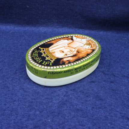 Green candy tin with a decorative lid on a blue background