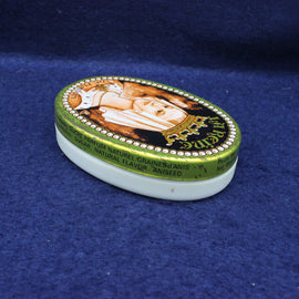 Small oval container with decorative lid featuring a portrait on a blue background
