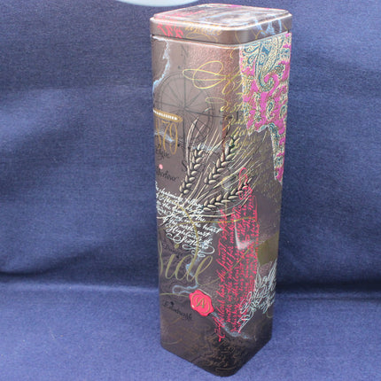 Decorative cylindrical container with intricate designs on a blue background