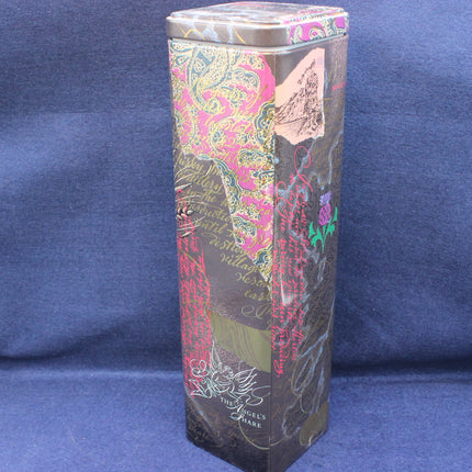 Decorative cylindrical box with intricate patterns on a blue background