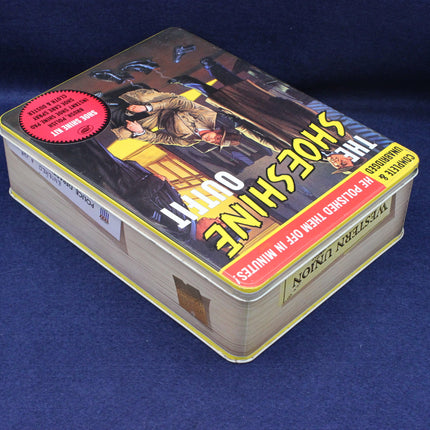 Tin box with 'The Shoeshine' book cover on a blue background
