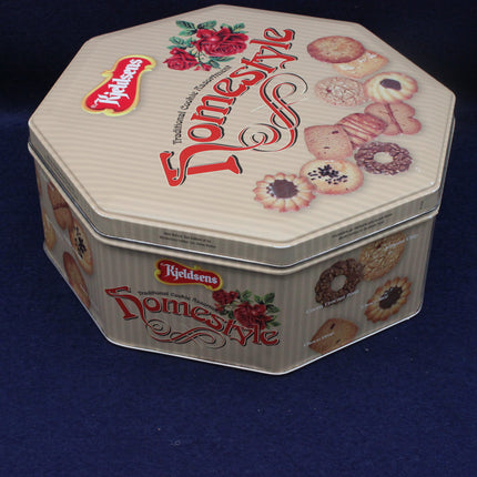 Hexagonal cookie tin with 'Kleidens' branding and images of cookies on a dark blue background