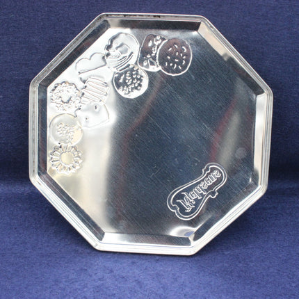 Silver octagonal tray with decorative embossing on a blue background