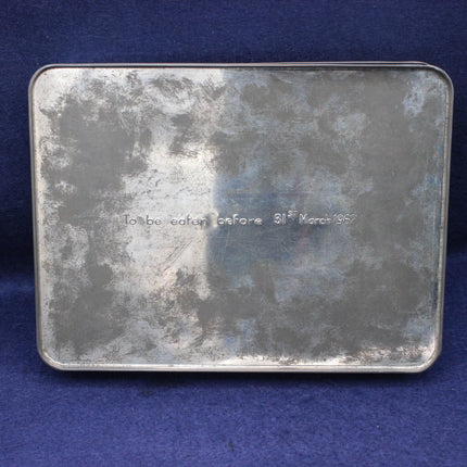 Metal tin with text 'To be eaten before 31st March 1967' on a blue background