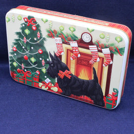 Decorative Christmas tin with a dog, tree, and fireplace design on a blue background