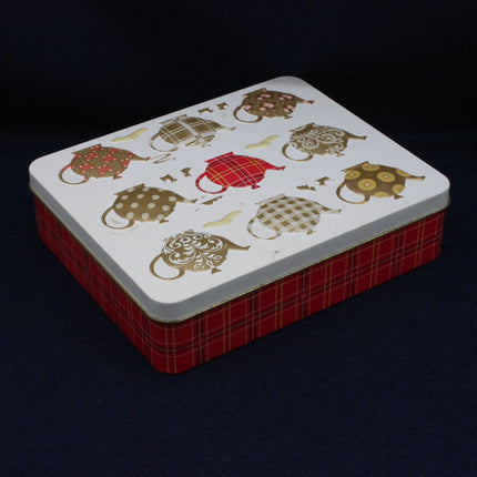 Upside down tea pots on a biscuit tin lid
