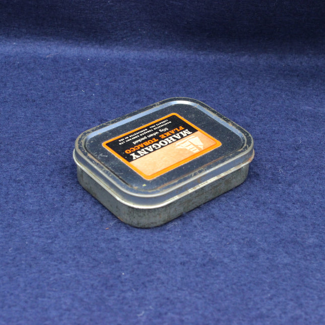 Angled shot of collectable Mahogany Flake tin highlighting classic advertising design.