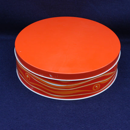 Stack of orange and white containers with decorative patterns on a dark blue background