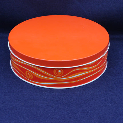 Orange tin with white accents on a blue background
