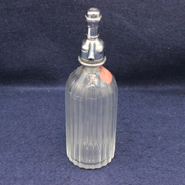Clear glass bottle with silver cap on a dark blue background