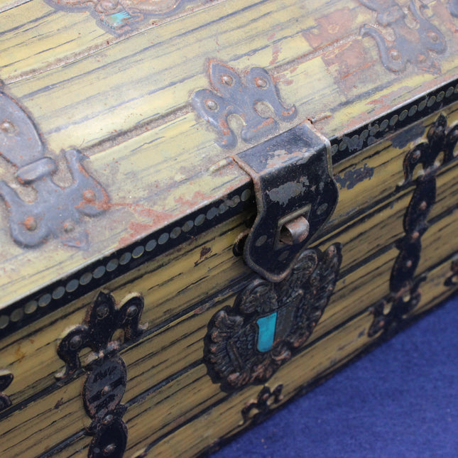Close-up of a wooden chest with decorative metal clasps and a blue interior.