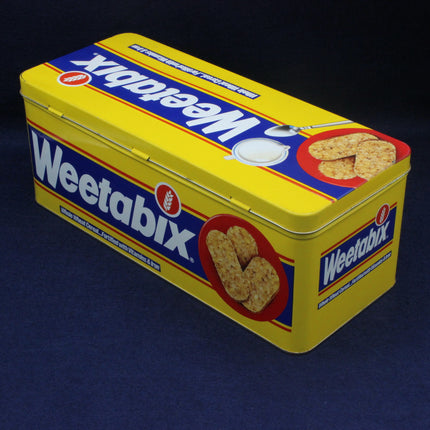 Yellow Weetabix tin with branding and product images on a dark background