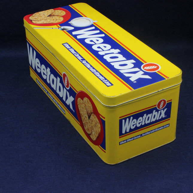 Yellow Weetabix cereal tin on a dark blue background