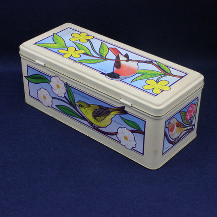 Decorative tin box with bird and floral design on a blue background