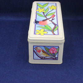 Rectangular tin box with bird and floral designs on a blue background