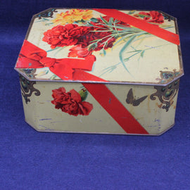 Decorative hexagonal tin box with floral design on a blue background