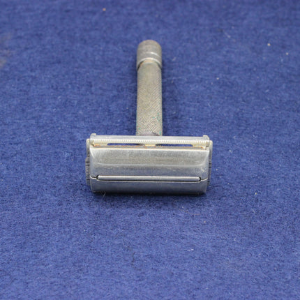 Silver safety razor on a blue textured background